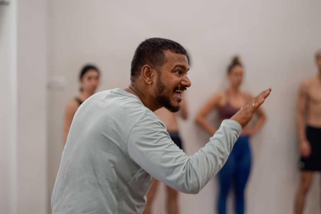 Hands-on adjustment during Ashtanga practice at the shala